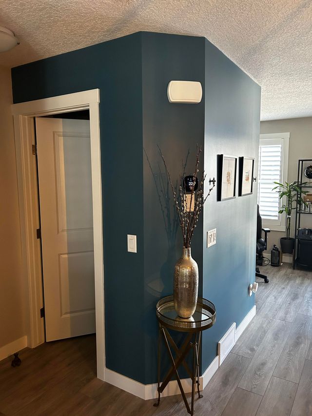 Painters Calgary transformed this cozy hallway with a vibrant turquoise wall and accents