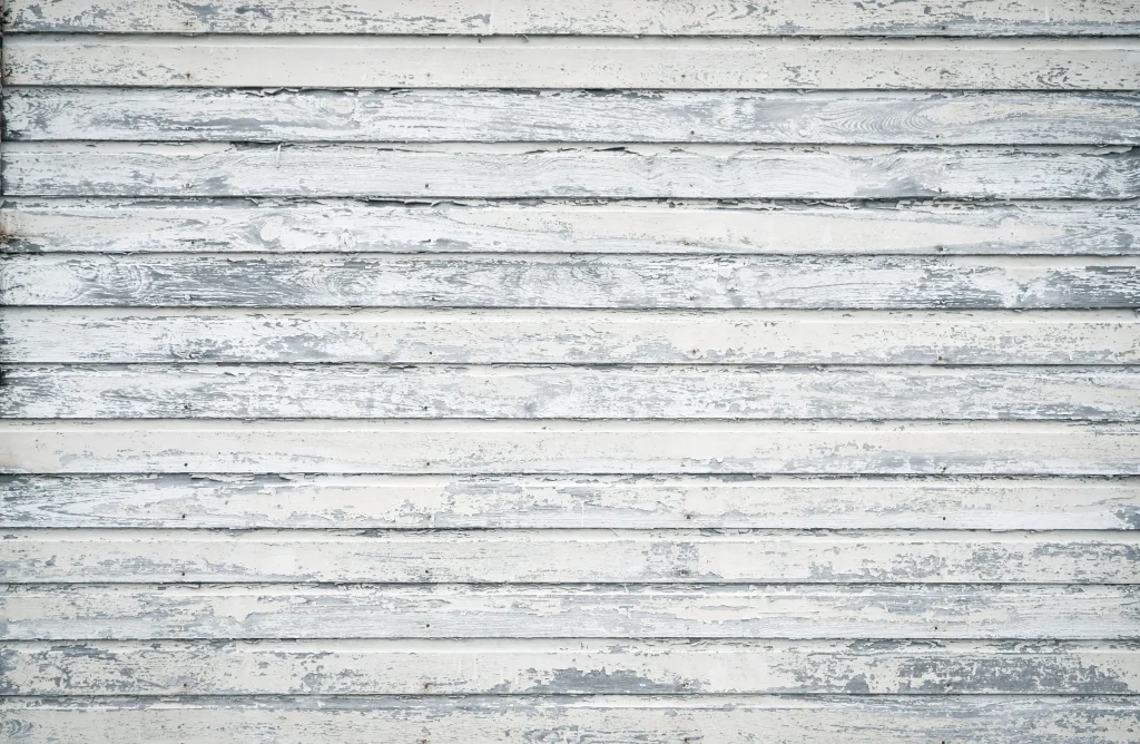 A weathered wooden surface displays faded white and gray horizontal lines