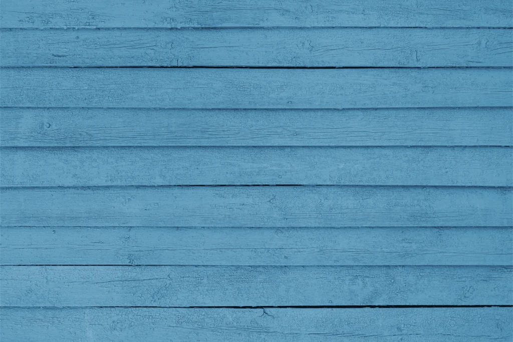Horizontal wooden planks are painted in a solid, vibrant blue color