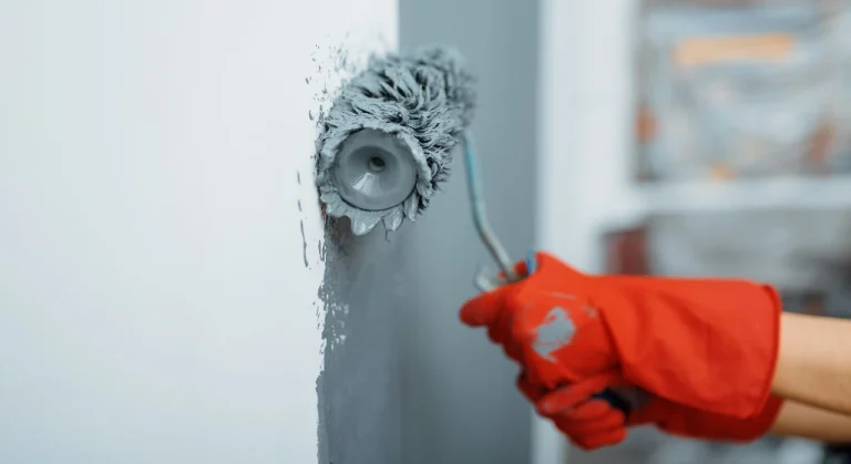 Interior Painter Copperfield applying gray paint to a wall with a roller